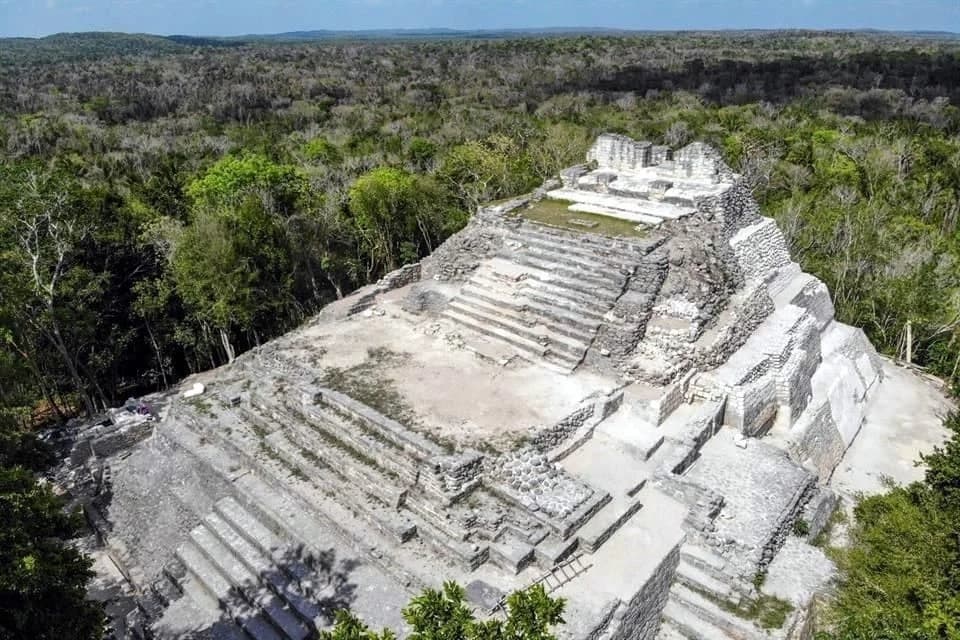 Ruinas de una estructura prehispánica escalonada rodeada de selva tropical densa.