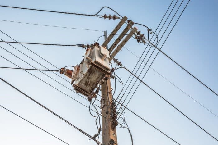 Poste de servicios con transformador eléctrico y líneas de CFE contra cielo despejado.