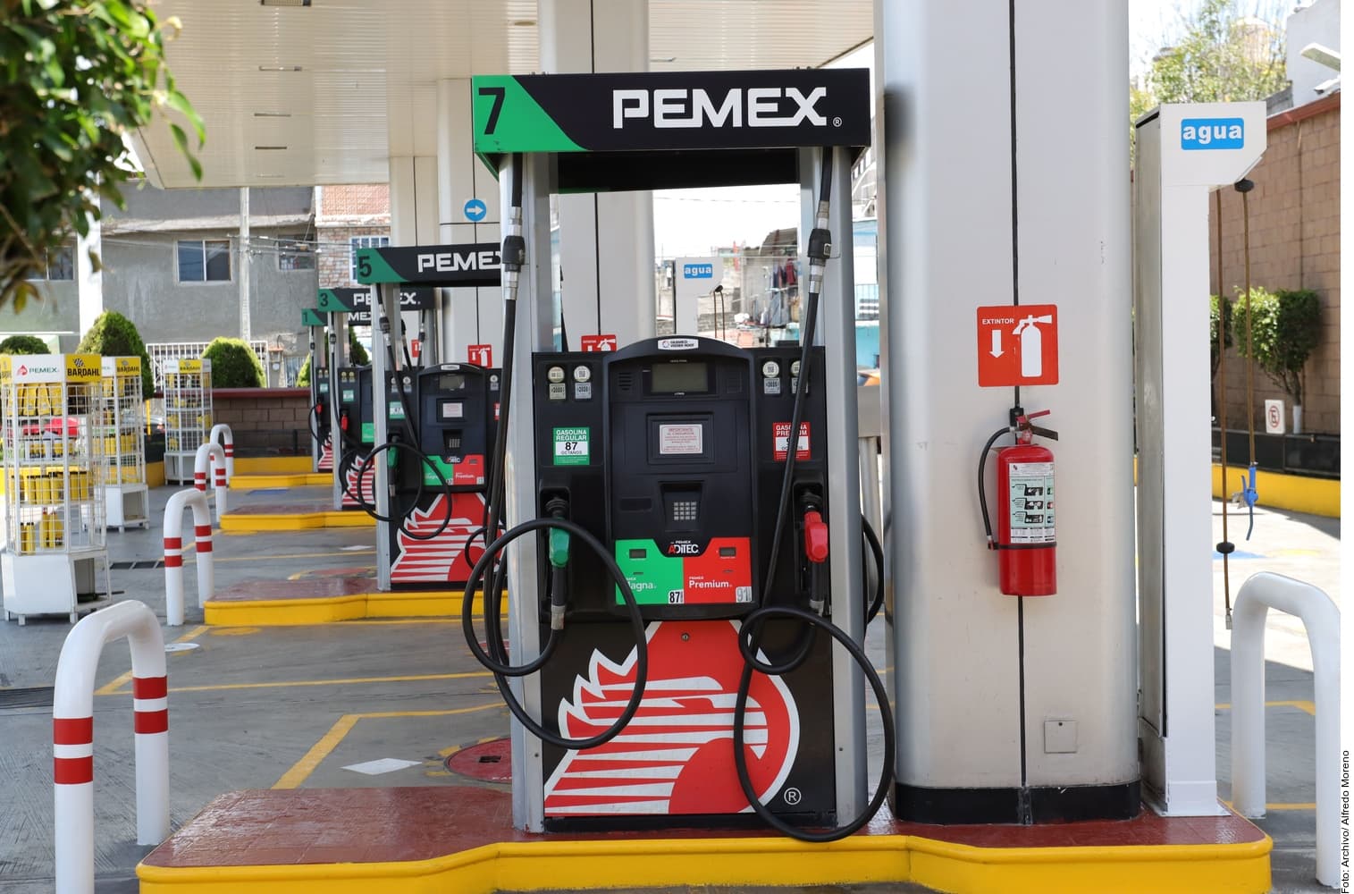 Bomba de gasolina Pemex número 7 en una gasolinera con surtidores de combustible premium y regular.