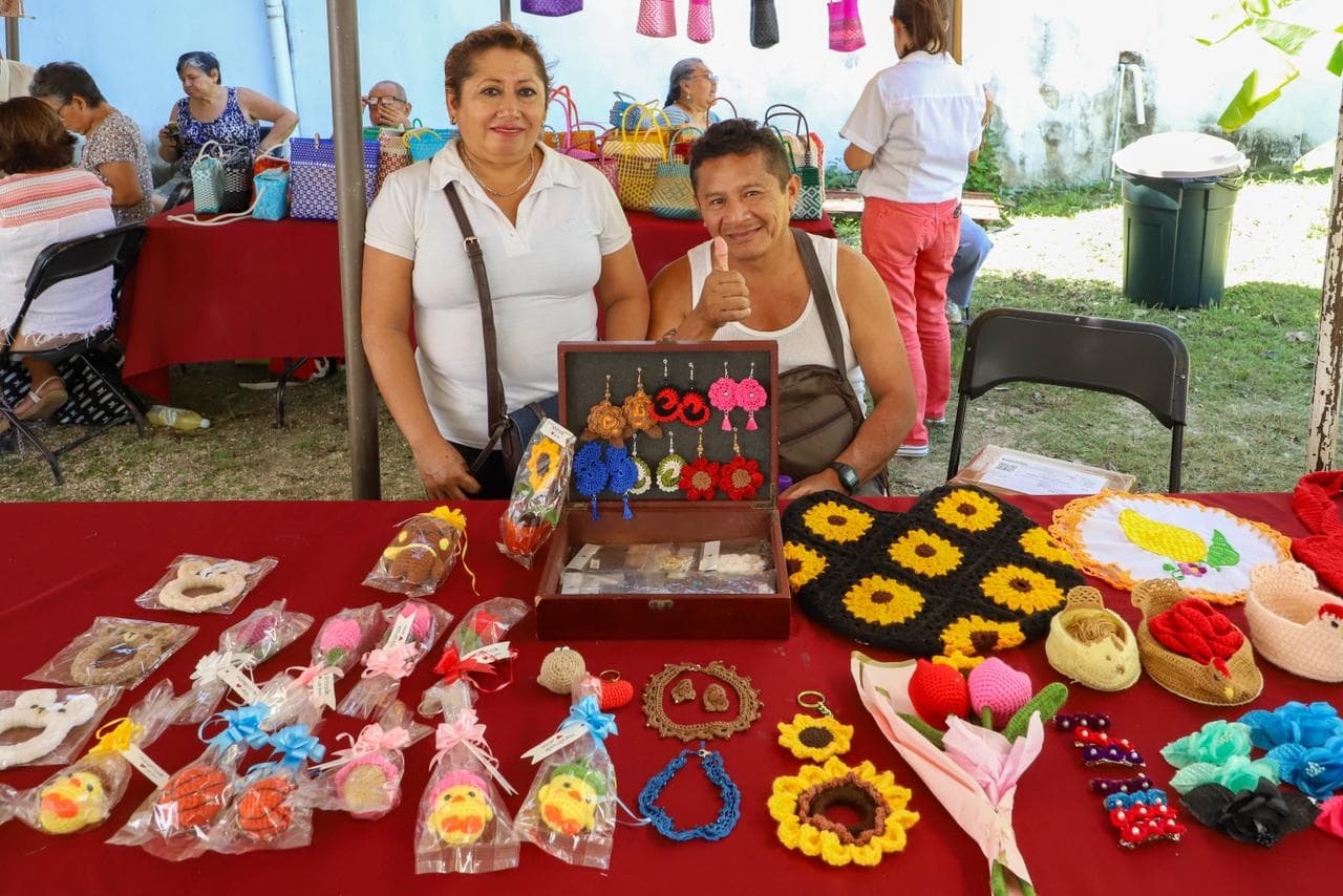 Dos emprendedoras presentan sus productos artesanales tejidos a crochet en una feria de negocios al aire libre.