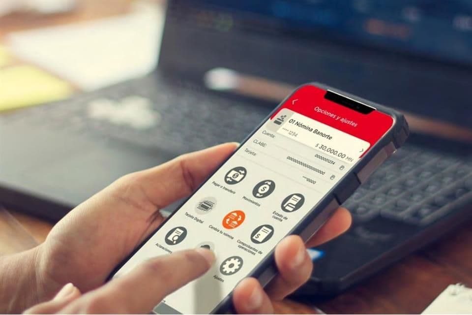 Mano sosteniendo un smartphone con interfaz de aplicación financiera mostrando saldo y opciones de transacciones bancarias.