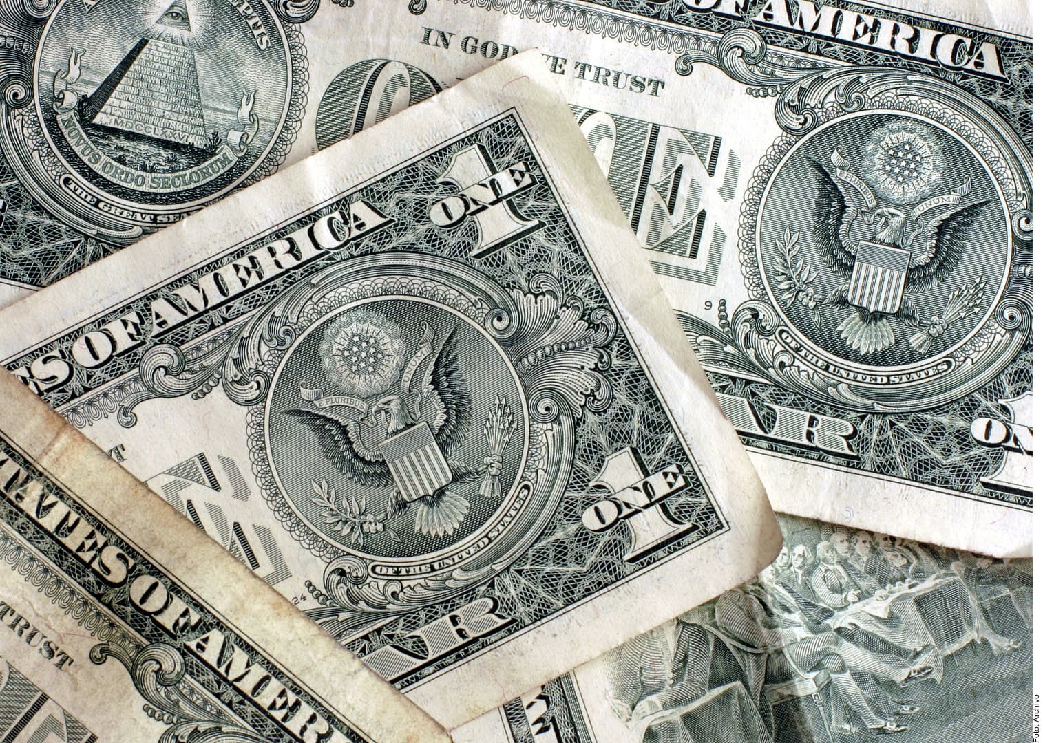 Billetes de dólar estadounidense apilados, mostrando detalles del águila y decoraciones de seguridad.