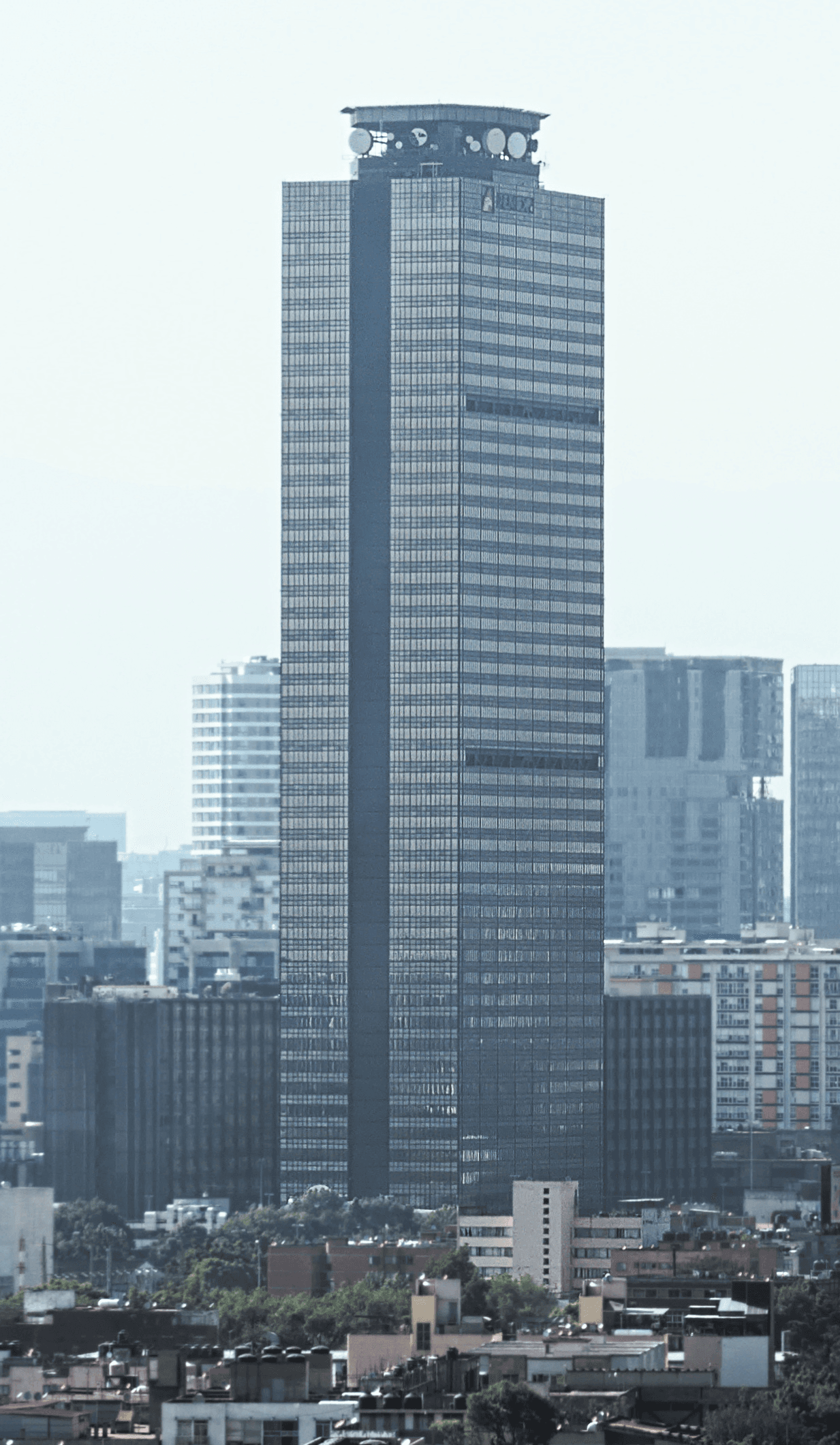 Edificio corporativo de gran altura con fachada de vidrio y estructura metálica en skyline urbano.