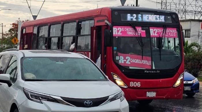 Autobús rojo número 806 de la empresa Autocar estacionado junto a vehículos particulares en una calle urbana.