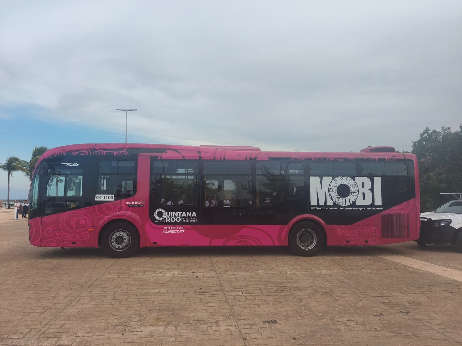 Autobús de la ruta MOBI 27 de color rosa estacionado en Cancún, con identificación visible de la operadora Turcut.