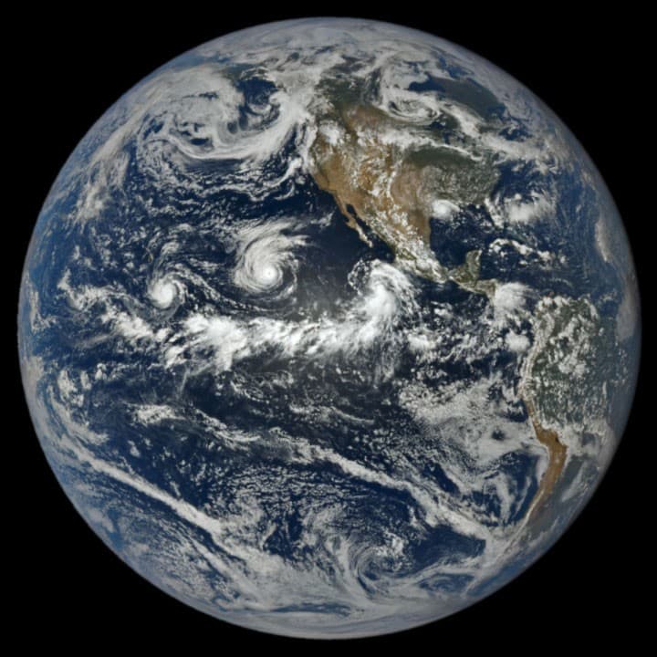 Imagen satelital de la Tierra mostrando tres sistemas ciclónicos en el océano Pacífico y condiciones tranquilas en el Atlántico.