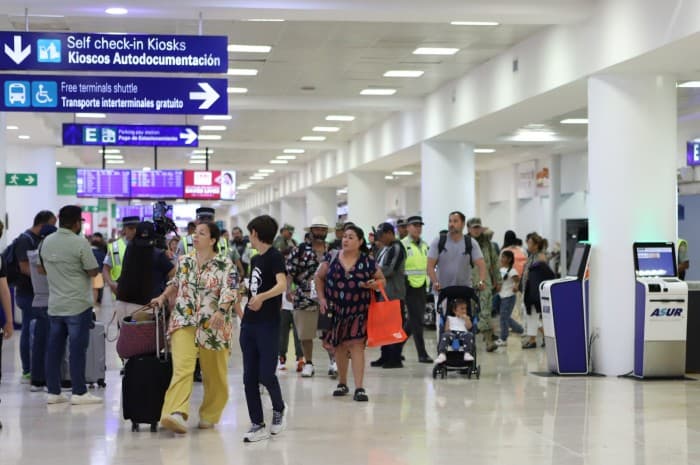 Pasajeros circulan por la terminal del Aeropuerto Internacional de Cancún durante operaciones de vuelos.