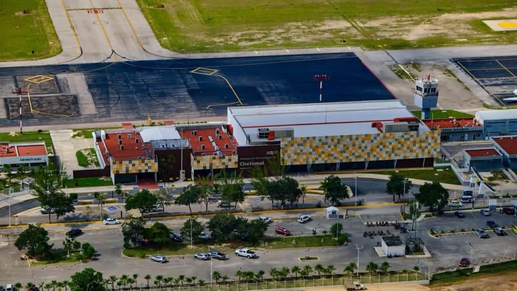 Vista aérea de complejo comercial e industrial con edificios de arquitectura moderna, estacionamientos y área de desarrollo en Chetumal.