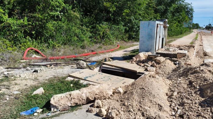 Obras de excavación y construcción en una vialidad con maquinaria, materiales de construcción y estructuras en desarrollo.