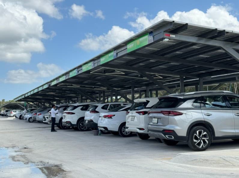 Estacionamiento con vehículos rentados bajo techo solar, mostrando baja ocupación de espacios disponibles.