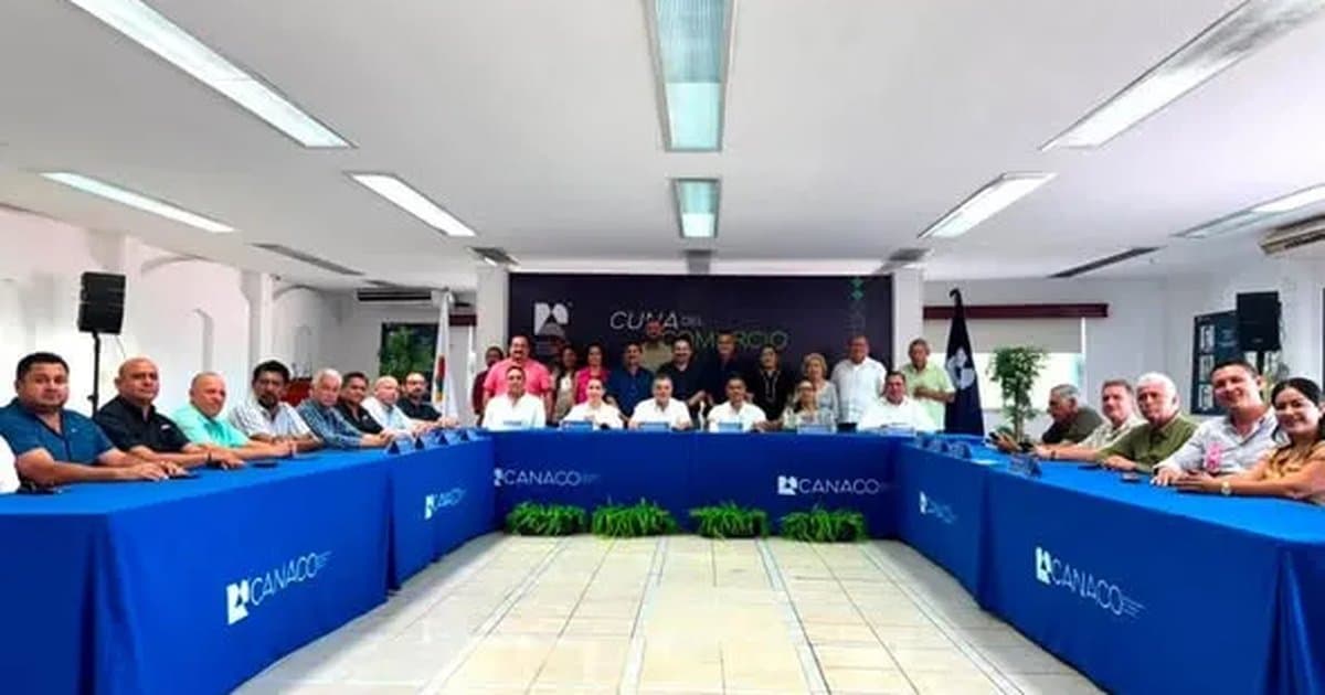 Reunión de directivos y empresarios en sala de conferencias con mesa presidencial azul de Canaco Chetumal durante presentación de proyecto.