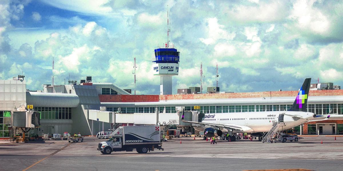 Aeropuerto Internacional de Cancún con control de tráfico aéreo, terminal y avión comercial estacionado en la pista.