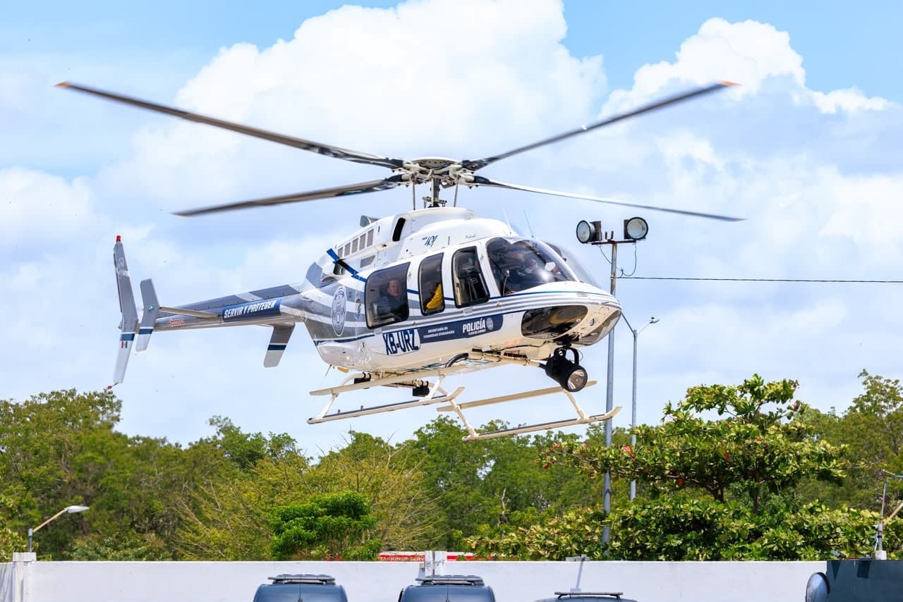 Helicóptero de la policía en vuelo sobre zona boscosa durante operativo de control.
